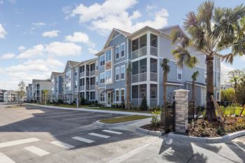 A large apartment complex with a parking lot in front.